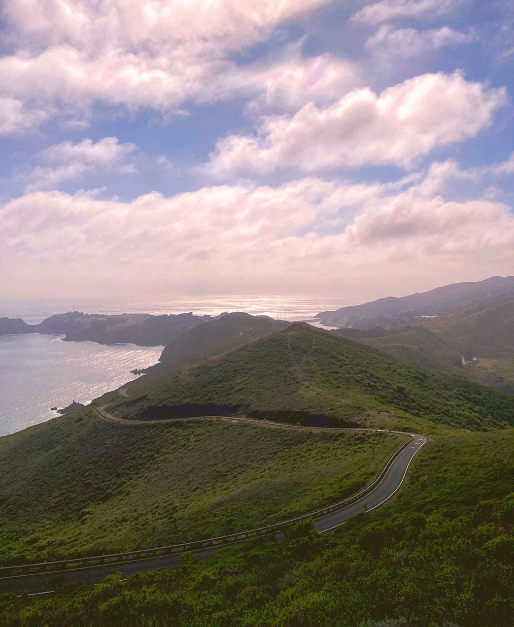 hills of marin headlands with winding road and ocean in the distance