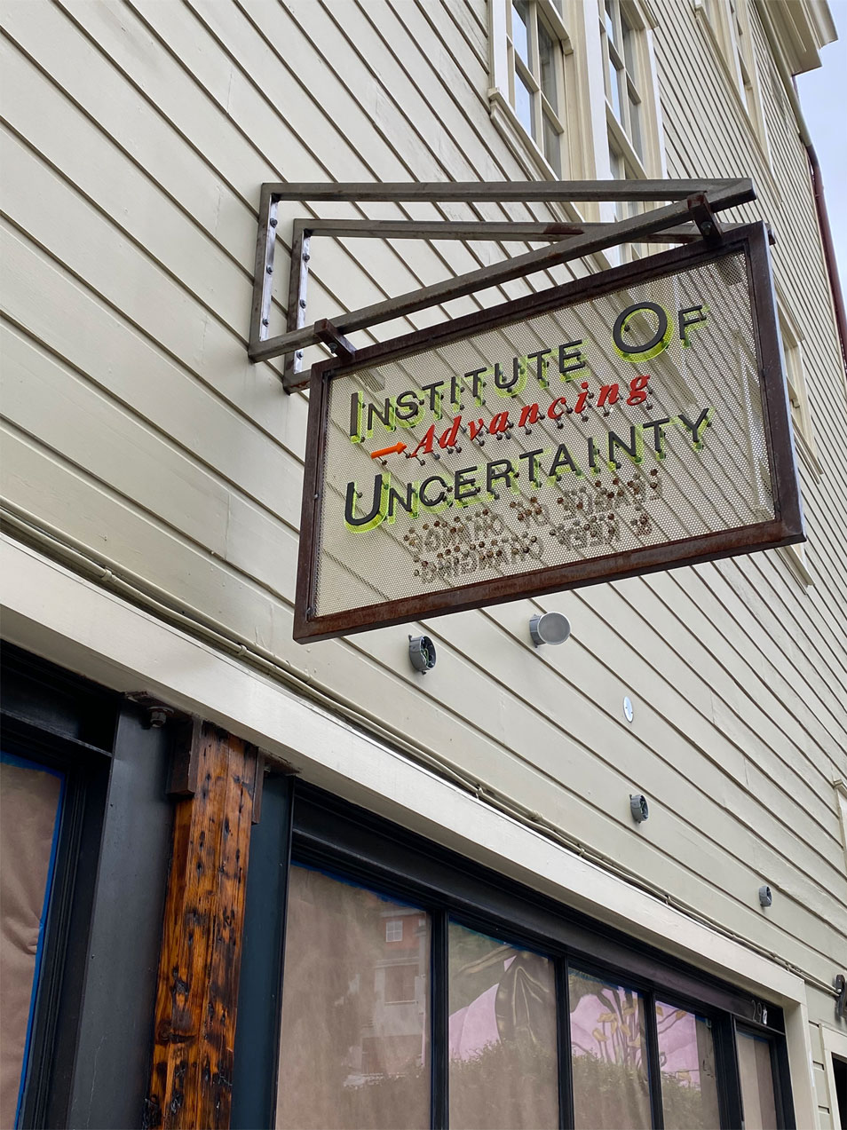 a storefront sign for the "Institute of Advancing Uncertainty"